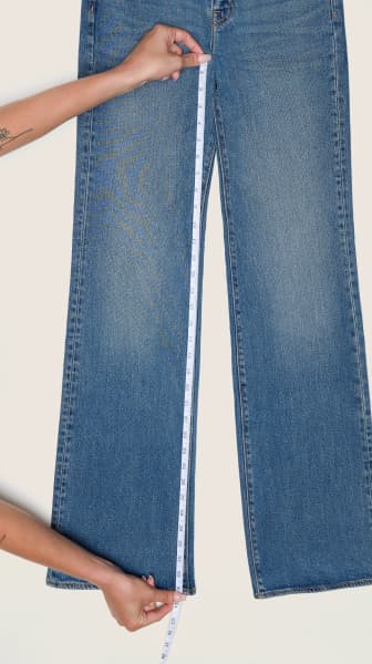 Placez le ruban à mesurer de la couture de la fourche à l'ourlet d'une paire de jeans.