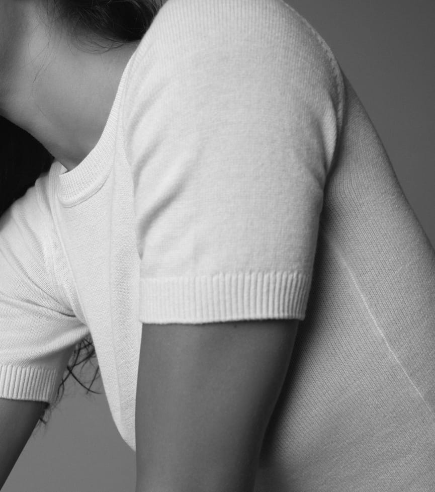 Une mannequin porte une chemise beige à manches courtes avec un pantalon beige.
