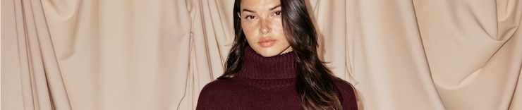 Model is wearing a beige faux fur coat.