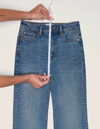 Placez le ruban à mesurer du haut de la bande de taille jusqu'au bas de la couture de la fourche d'une paire de jeans.