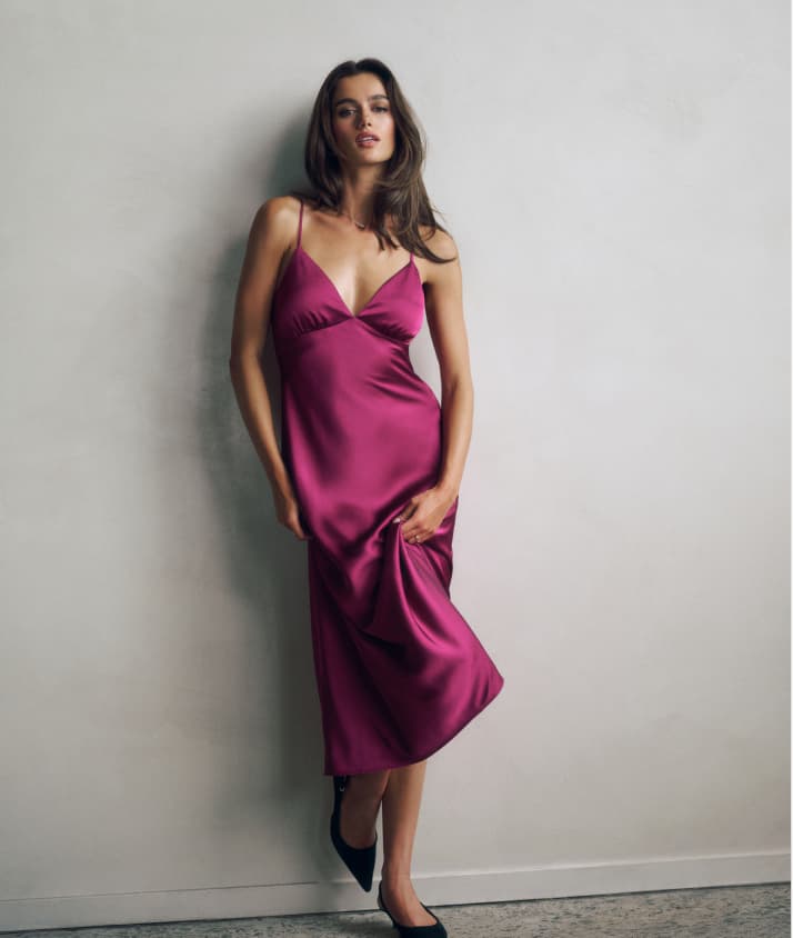 Model is wearing a pink satin maxi dress.