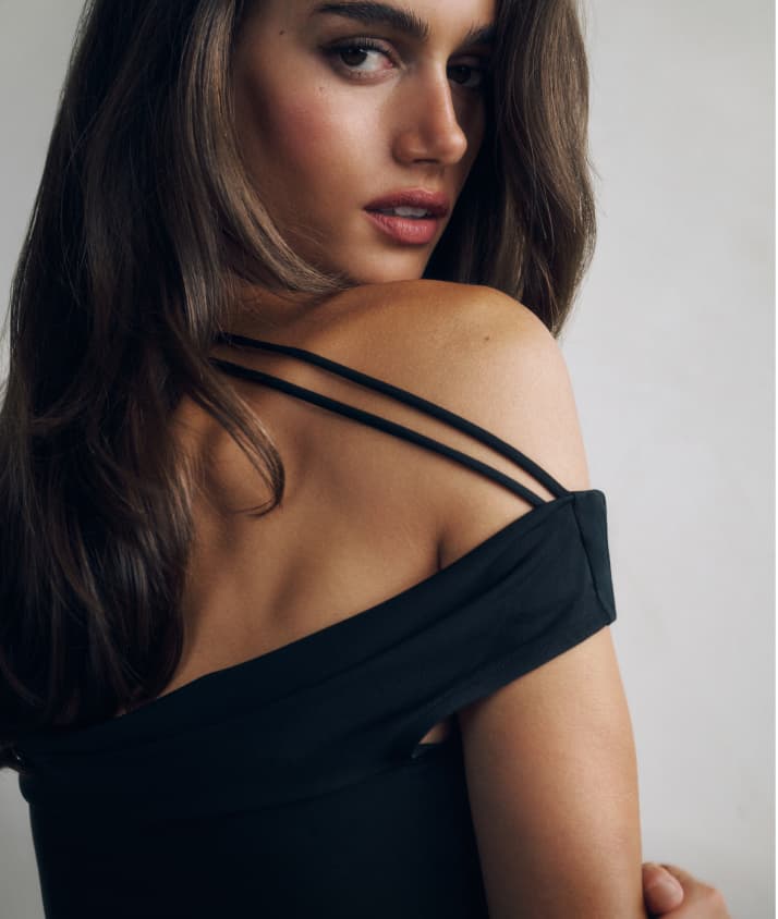 Model is wearing a black open back top.